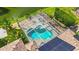 Aerial view of a screened-in pool with spa, complemented by solar panels and lush landscaping at 3620 Cordgrass Dr, Valrico, FL 33596