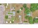 A bird's eye view of a parcel of land with several buildings, trees, and surrounded by a white fence at 3715 Fortner Rd, Plant City, FL 33567