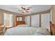 Spacious bedroom featuring two closets, warm lighting, and a rustic wooden bed frame and dresser at 3715 Fortner Rd, Plant City, FL 33567