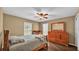 Warm bedroom featuring a rustic wood bed, dresser, and ample natural light from a large window at 3715 Fortner Rd, Plant City, FL 33567