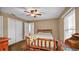 Comfortable bedroom featuring a rustic wooden bed frame, ceiling fan, and natural light from blinds at 3715 Fortner Rd, Plant City, FL 33567