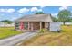 Welcoming single-story home featuring a cozy covered porch, vibrant red front door, and green lawn at 3715 Fortner Rd, Plant City, FL 33567