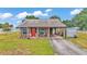Inviting single-story home with covered front porch, red front door, and driveway, perfect for relaxing at 3715 Fortner Rd, Plant City, FL 33567