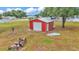 Detached red outbuilding and storage structure with a white roll-up door located on the property at 3715 Fortner Rd, Plant City, FL 33567