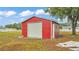 Red outbuilding with roll-up door, side door, and ample storage space, situated on a spacious lot at 3715 Fortner Rd, Plant City, FL 33567