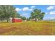 View of the red outbuilding and spacious yard of a property at 3715 Fortner Rd, Plant City, FL 33567