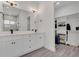 Bright bathroom featuring a double sink vanity, decorative lighting, and an attached walk-in closet with shelving at 5227 Lime Ave, Seffner, FL 33584