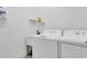 Clean laundry room with washing machine, dryer, utility sink, and shelving providing practical functionality at 5227 Lime Ave, Seffner, FL 33584