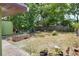 An expansive backyard with a wooden planter, a shade tree, and a partial view of the lawn at 10804 N Leo St, Tampa, FL 33612