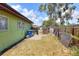 View of backyard with wooden fence, a utility door and lime green painted siding at 10804 N Leo St, Tampa, FL 33612
