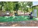 The backyard with turf, grill, outdoor fitness equipment, and a shaded lawn at 10804 N Leo St, Tampa, FL 33612