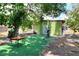 Wide backyard with artificial turf and outdoor fitness equipment beneath a large shade tree at 10804 N Leo St, Tampa, FL 33612
