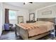 Comfortable bedroom with hardwood floors, natural light, dresser, mirror and seating area at 10804 N Leo St, Tampa, FL 33612