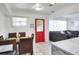Bright dining room with white walls, a red door, and an adjacent living area at 10804 N Leo St, Tampa, FL 33612