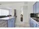 Well-lit kitchen showing blue cabinets, white countertops, and a view of the living room at 10804 N Leo St, Tampa, FL 33612