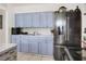 Kitchen featuring sleek stainless steel refrigerator, light blue cabinets, and white countertops at 10804 N Leo St, Tampa, FL 33612