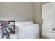 Bright laundry area with washer, dryer, and a bookshelf providing extra storage at 10804 N Leo St, Tampa, FL 33612