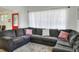 Spacious living room with plush sectional couch, large windows, and bright red front door at 10804 N Leo St, Tampa, FL 33612