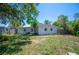 Lawn of the backyard with a mix of grass and sand. The house is white and medium sized at 6011 67Th N Ave, Pinellas Park, FL 33781