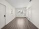 A sunny room with gray wood flooring and white walls, featuring doors to other spaces at 6011 67Th N Ave, Pinellas Park, FL 33781