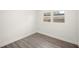 Bright bedroom featuring hardwood floors, white walls, and a window offering natural light at 6011 67Th N Ave, Pinellas Park, FL 33781