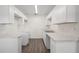 Modern kitchen boasts new white cabinets, countertops, and gray wood-look flooring at 6011 67Th N Ave, Pinellas Park, FL 33781