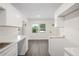 Updated kitchen with white cabinets, gray countertops, new flooring, and ample natural light at 6011 67Th N Ave, Pinellas Park, FL 33781