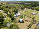 Aerial view of home with large backyard, screened pool, long driveway, and lush landscaping at 9912 Pine Leaf Ln, Dade City, FL 33525