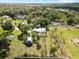 Expansive property featuring a single-Gathering home, separate garage, and refreshing pool surrounded by lush greenery at 9912 Pine Leaf Ln, Dade City, FL 33525