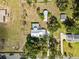 Aerial view of a property featuring a single-Gathering home, separate garage, and refreshing pool at 9912 Pine Leaf Ln, Dade City, FL 33525
