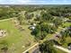 Aerial view of a property with expansive green spaces, a swimming pool, and mature trees at 9912 Pine Leaf Ln, Dade City, FL 33525