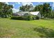 Large green backyard featuring a screened pool and lush landscaping at 9912 Pine Leaf Ln, Dade City, FL 33525