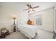 Cozy bedroom with a white bed, ceiling fan, and ample natural light at 9912 Pine Leaf Ln, Dade City, FL 33525