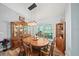 Cozy dining room with a wooden table, china cabinet, and natural light at 9912 Pine Leaf Ln, Dade City, FL 33525