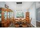 Warm dining room with a wood table, seating for six, and a cabinet for ample storage at 9912 Pine Leaf Ln, Dade City, FL 33525