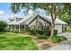 Charming home with a manicured lawn, lush landscaping, and a welcoming front porch at 9912 Pine Leaf Ln, Dade City, FL 33525