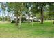 Inviting home featuring a large front yard, mature trees, and classic architectural details at 9912 Pine Leaf Ln, Dade City, FL 33525