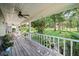 Expansive covered front porch with white railings, overlooking a lush green yard at 9912 Pine Leaf Ln, Dade City, FL 33525