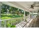 Relaxing porch with white railings, ceiling fans, and scenic views of the lush front yard at 9912 Pine Leaf Ln, Dade City, FL 33525