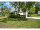 Two car garage surrounded by lush landscaping with a spacious driveway at 9912 Pine Leaf Ln, Dade City, FL 33525