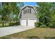 Spacious two-car garage or barn with a gable roof, complemented by lush green landscaping at 9912 Pine Leaf Ln, Dade City, FL 33525