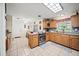 Bright kitchen features tiled floors, a center island, and classic wooden cabinets at 9912 Pine Leaf Ln, Dade City, FL 33525