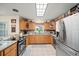 Traditional kitchen featuring stainless steel appliances, granite countertops, and tile flooring at 9912 Pine Leaf Ln, Dade City, FL 33525