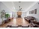 Spacious living room features a brick fireplace, ceiling fan, wood-look floors, and ample seating for entertaining at 9912 Pine Leaf Ln, Dade City, FL 33525