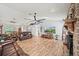 Open-concept living area featuring hardwood floors, brick fireplace, and comfortable seating at 9912 Pine Leaf Ln, Dade City, FL 33525