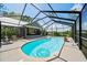 View of screened in pool with tube and pool patio with chairs at 9912 Pine Leaf Ln, Dade City, FL 33525