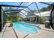 Screened in pool with stone finishings, and landscaped backyard at 9912 Pine Leaf Ln, Dade City, FL 33525