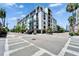 A modern, multi-story building with balconies and street views set against a blue sky with palm trees at 101 S 12Th St # 318, Tampa, FL 33602