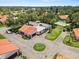 Aerial view of home highlighting tile roof, driveway, green lawn, mature trees and community pool at 107 Seville N Ct, Plant City, FL 33566
