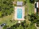 Overhead view of a community pool with several people sunbathing and swimming, lined by trees and green grass at 107 Seville N Ct, Plant City, FL 33566